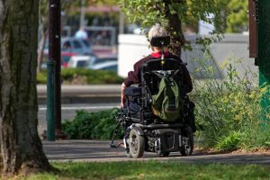 A person in a wheelchair on the sidewalk.