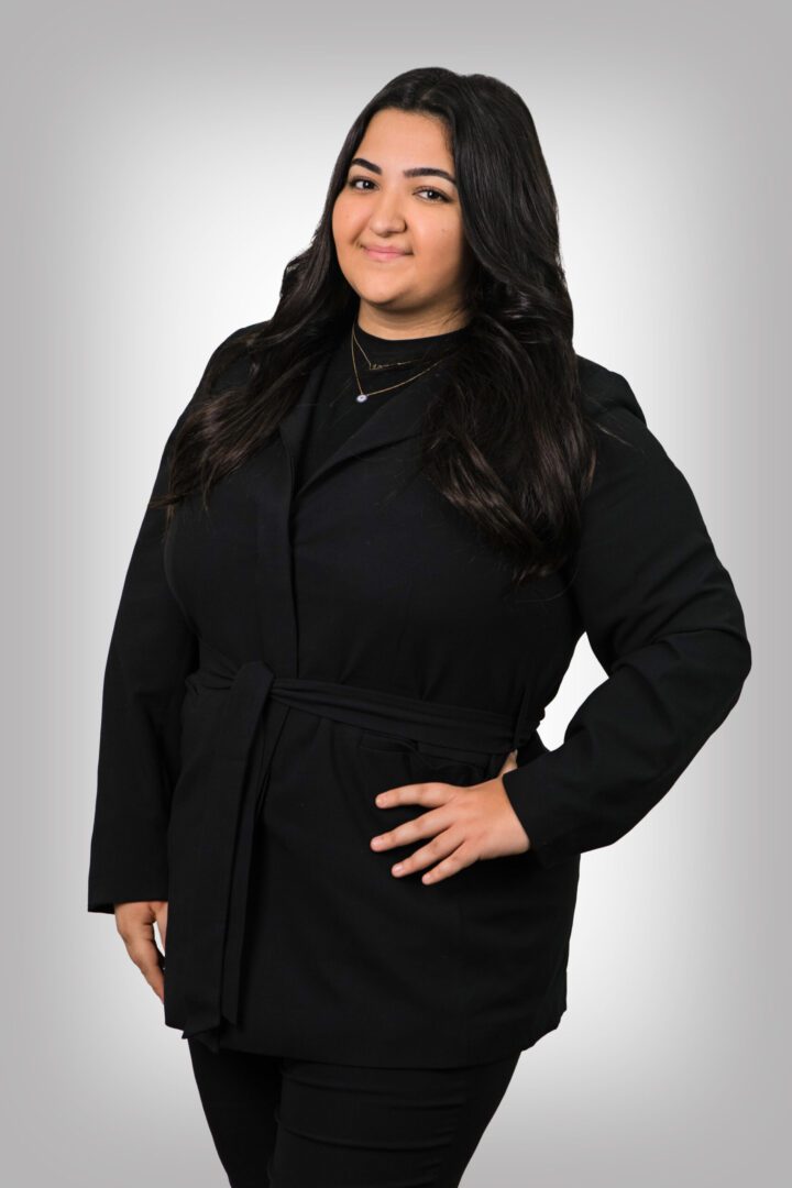 A woman in black coat posing for the camera.